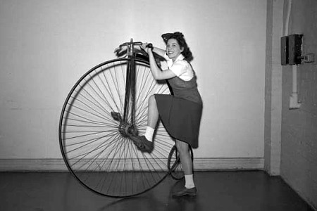 Woman mounting a bicycle